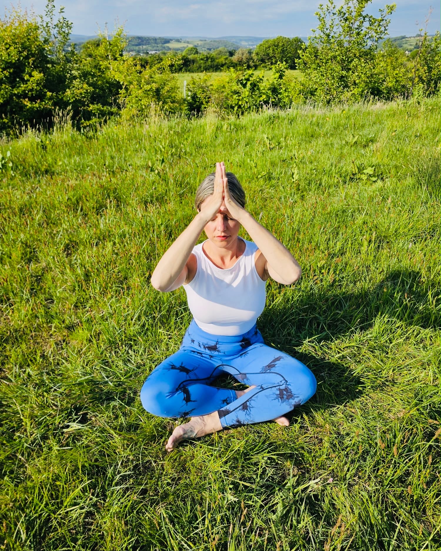 Celene seated in meditation in a meadow